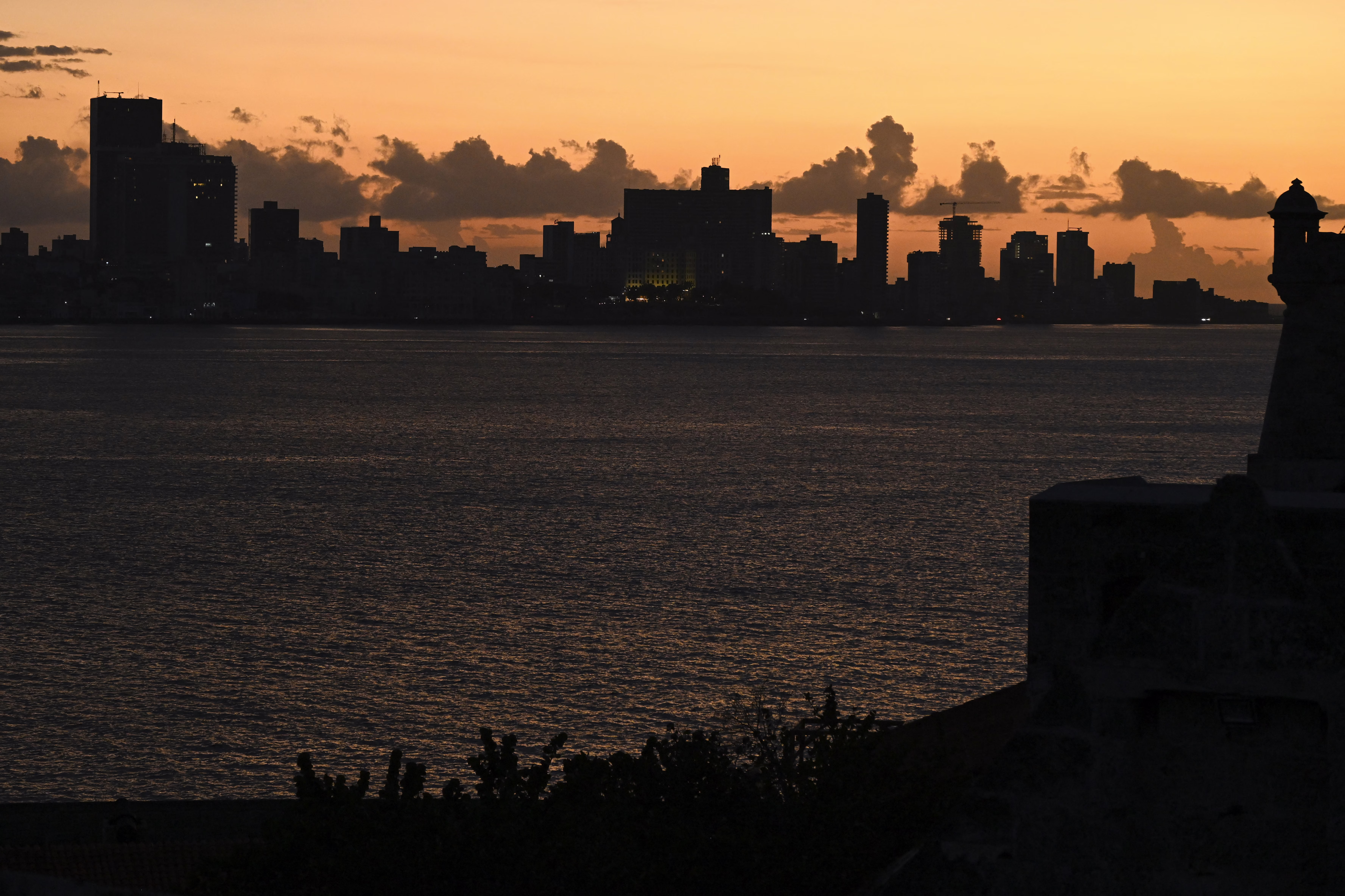 A dark city skyline, seen at sunset during a blackout