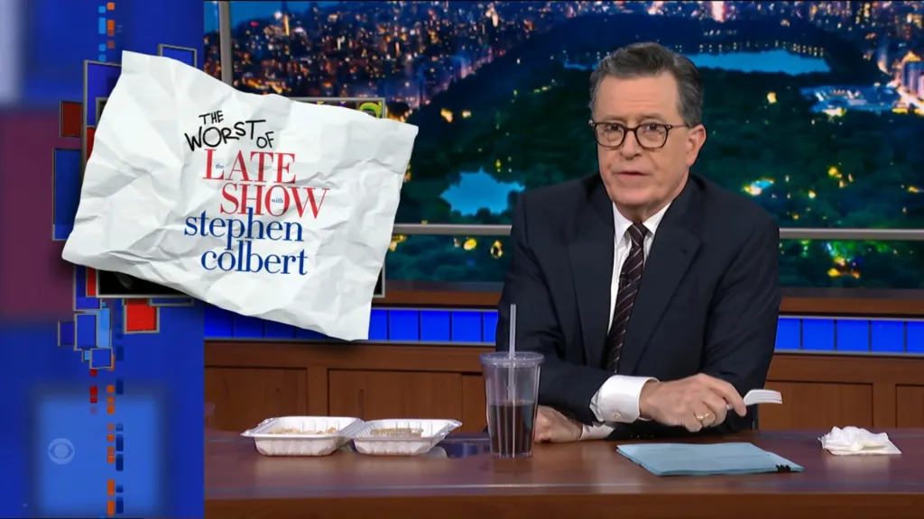 Stephen Colbert sitting at his desk with food and drink, with a graphic that reads 