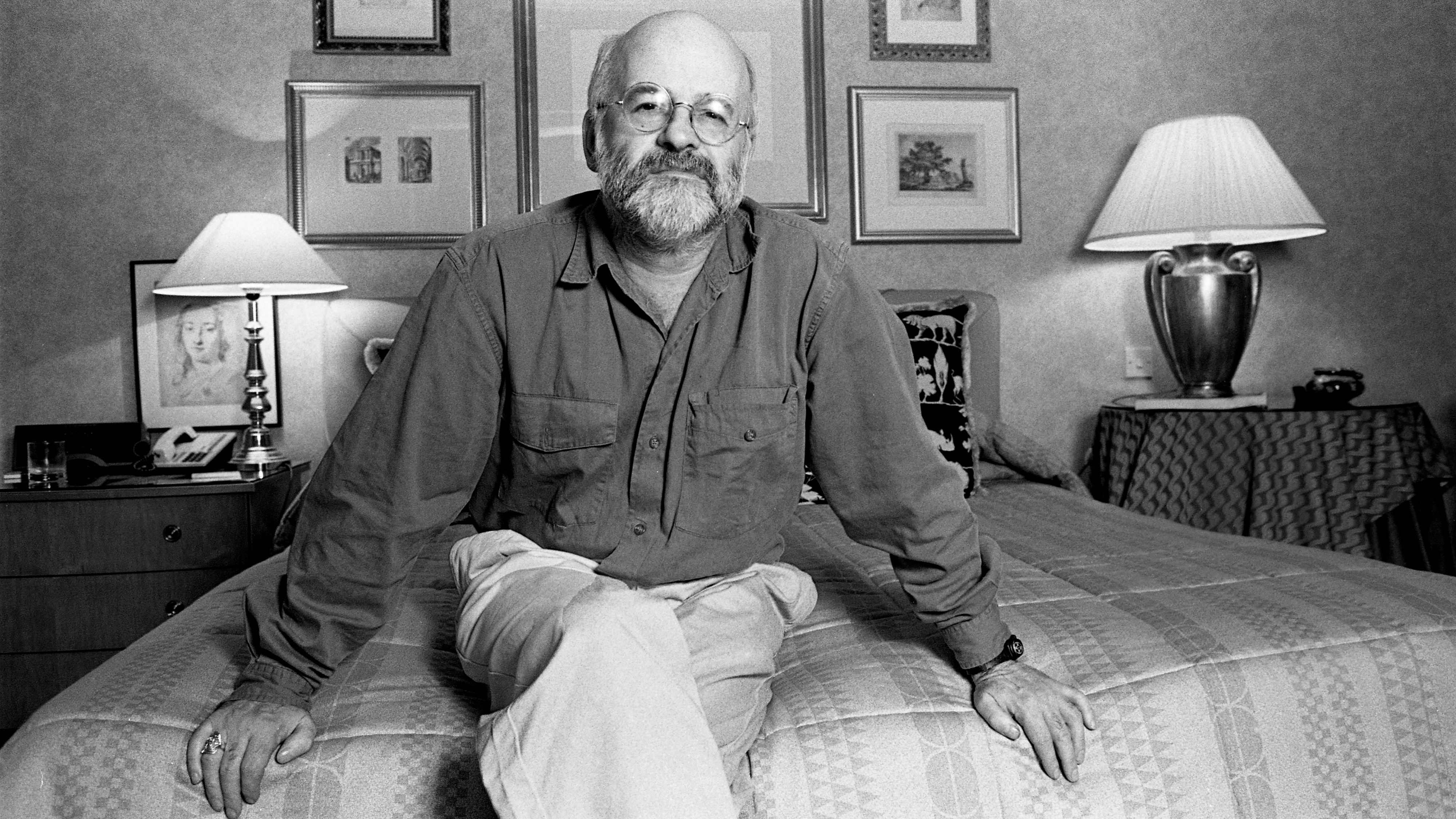 An image of Terry Pratchett sitting on a bed.