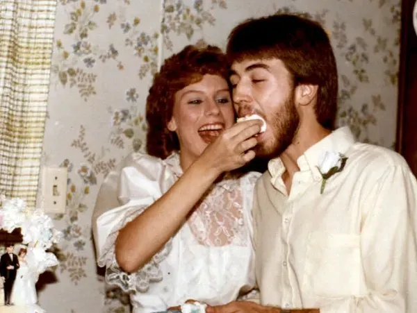 A young woman feeds a piece of cake to a young man.