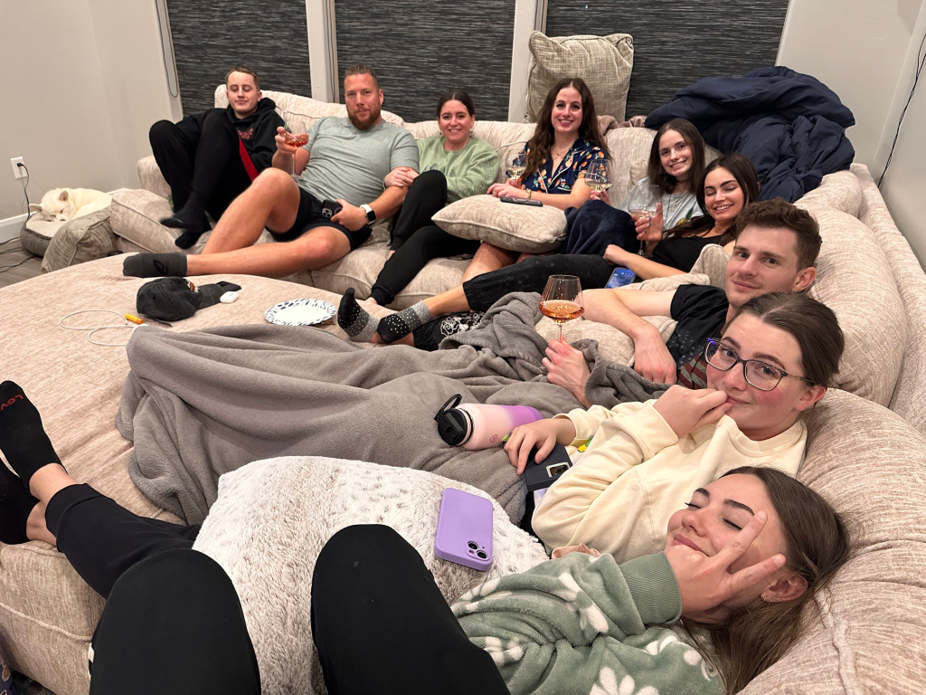 A group of friends relaxing on a large couch.