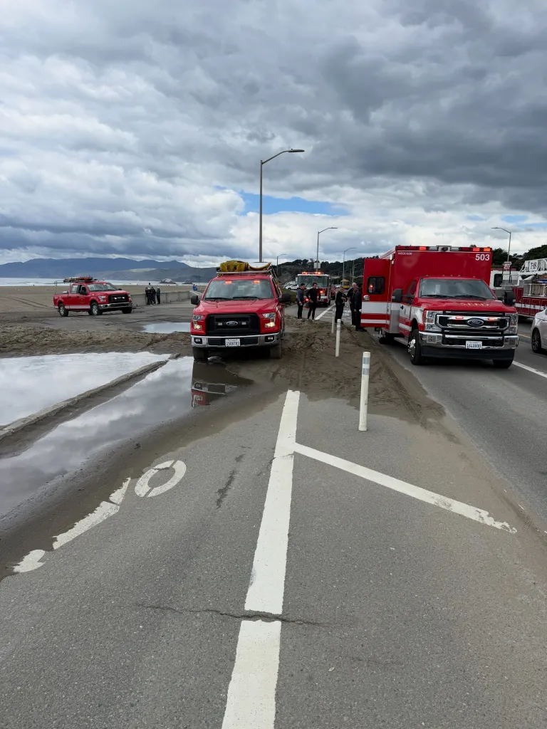 San Francisco Fire Department vehicles responding to a distressed surfer at Ocean Beach.