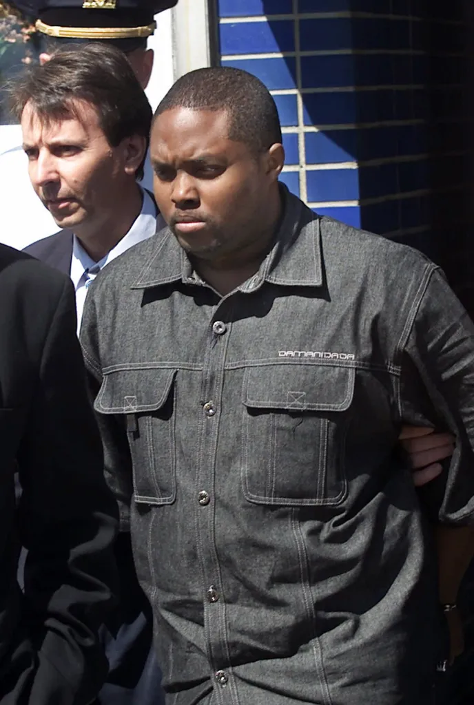 Police lead John Taylor, convicted of murder, out of a police station.