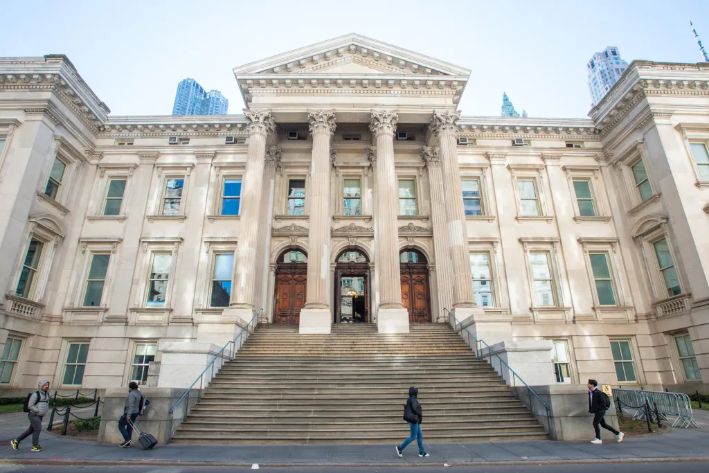 Tweed Courthouse in New York City with people walking outside.