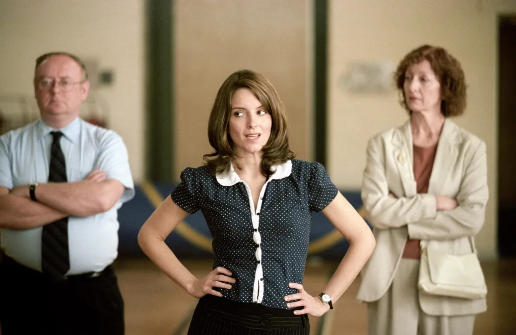 Tina Fey as Ms. Norbury, with two other adults behind her, in 