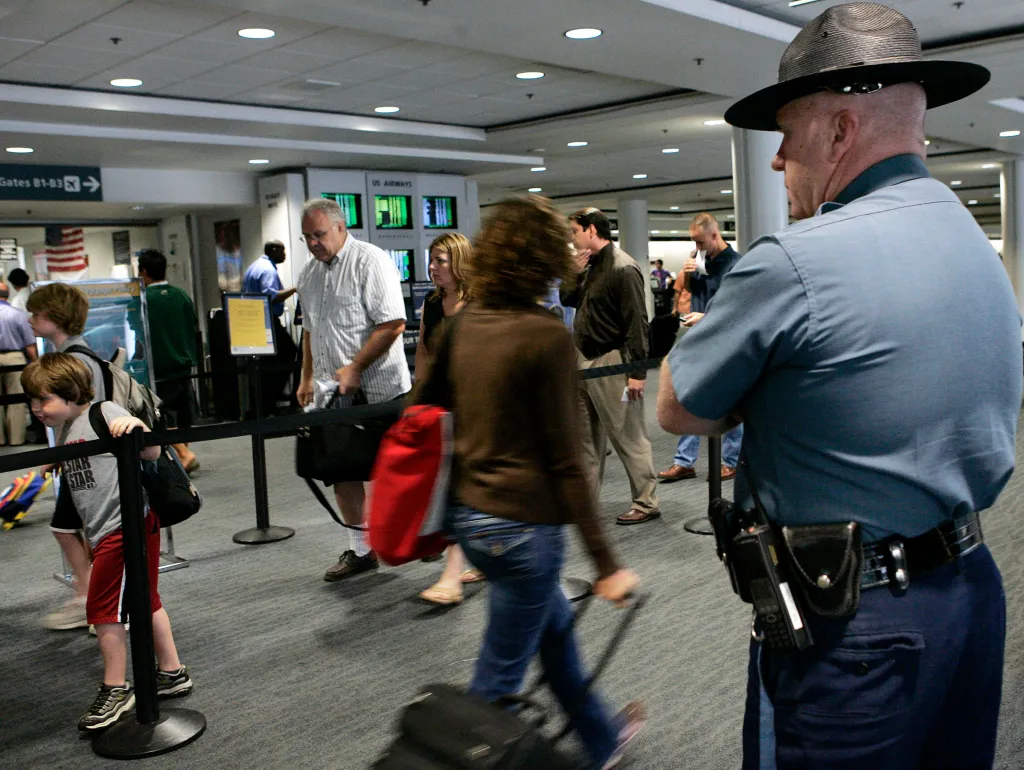 A Massachusetts state trooper watches travelers at Logan International Airport.