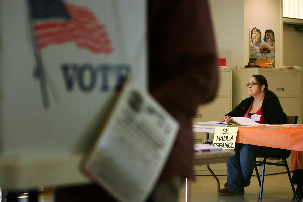 A woman election official at a table with a