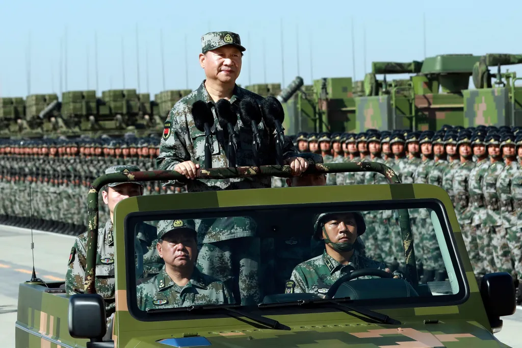 Chinese President Xi Jinping stands on a military jeep as he inspects troops of the People's Liberation Army during a military parade to commemorate the 90th anniversary of the founding of the PLA