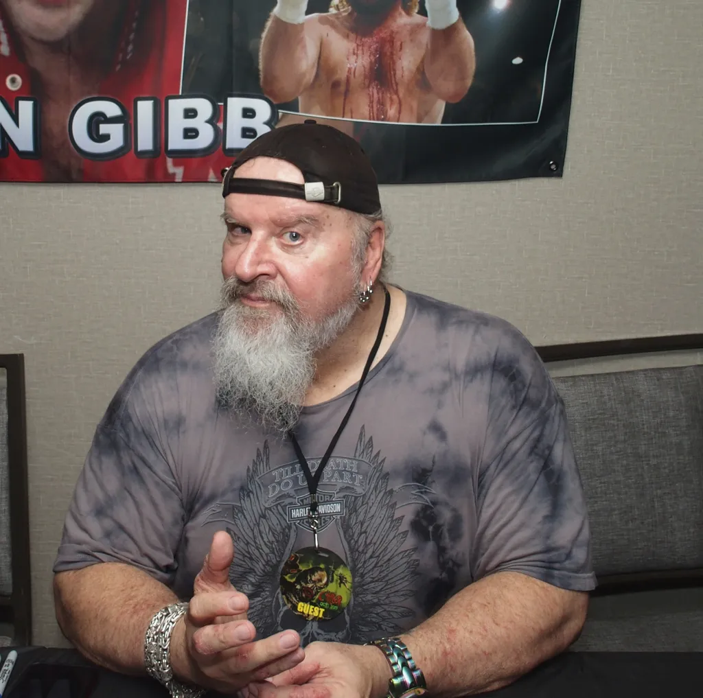 Donald Gibb sitting at the Chiller Theatre Expo Fall 2019.