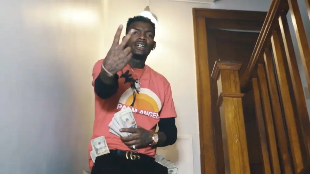 Rapper Fontrell Baines, also known as Nuke Bizzle, flashing money and making a hand gesture in a music video.