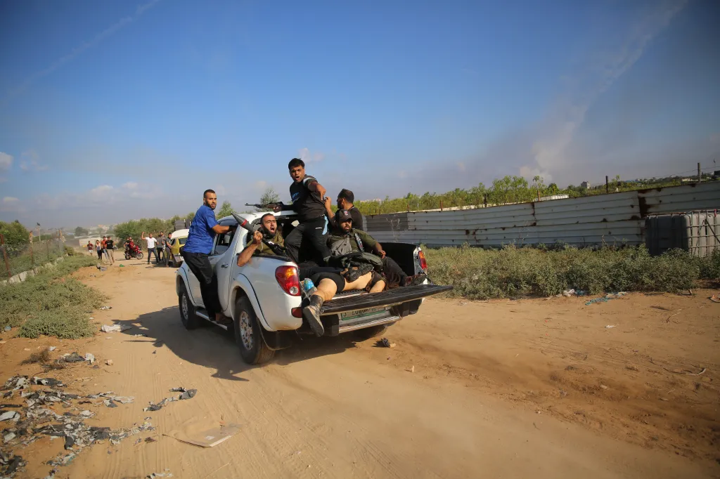 Palestinian militants drive in a pickup truck with the body of Shani Louk.