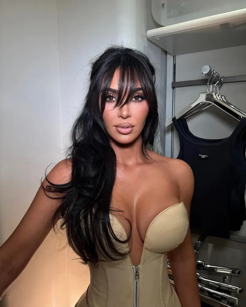 Kim Kardashian wearing a beige strapless top and bangs in her dark hair.