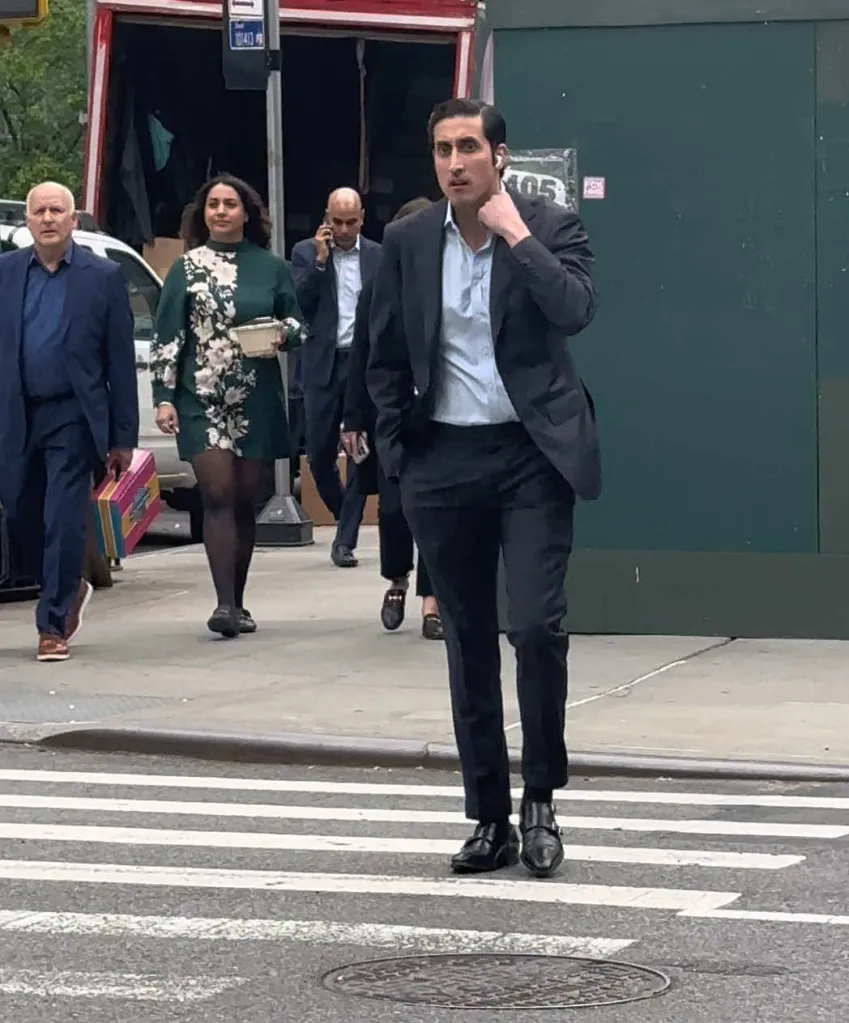 Chirayu Rana walking across a street in a suit.