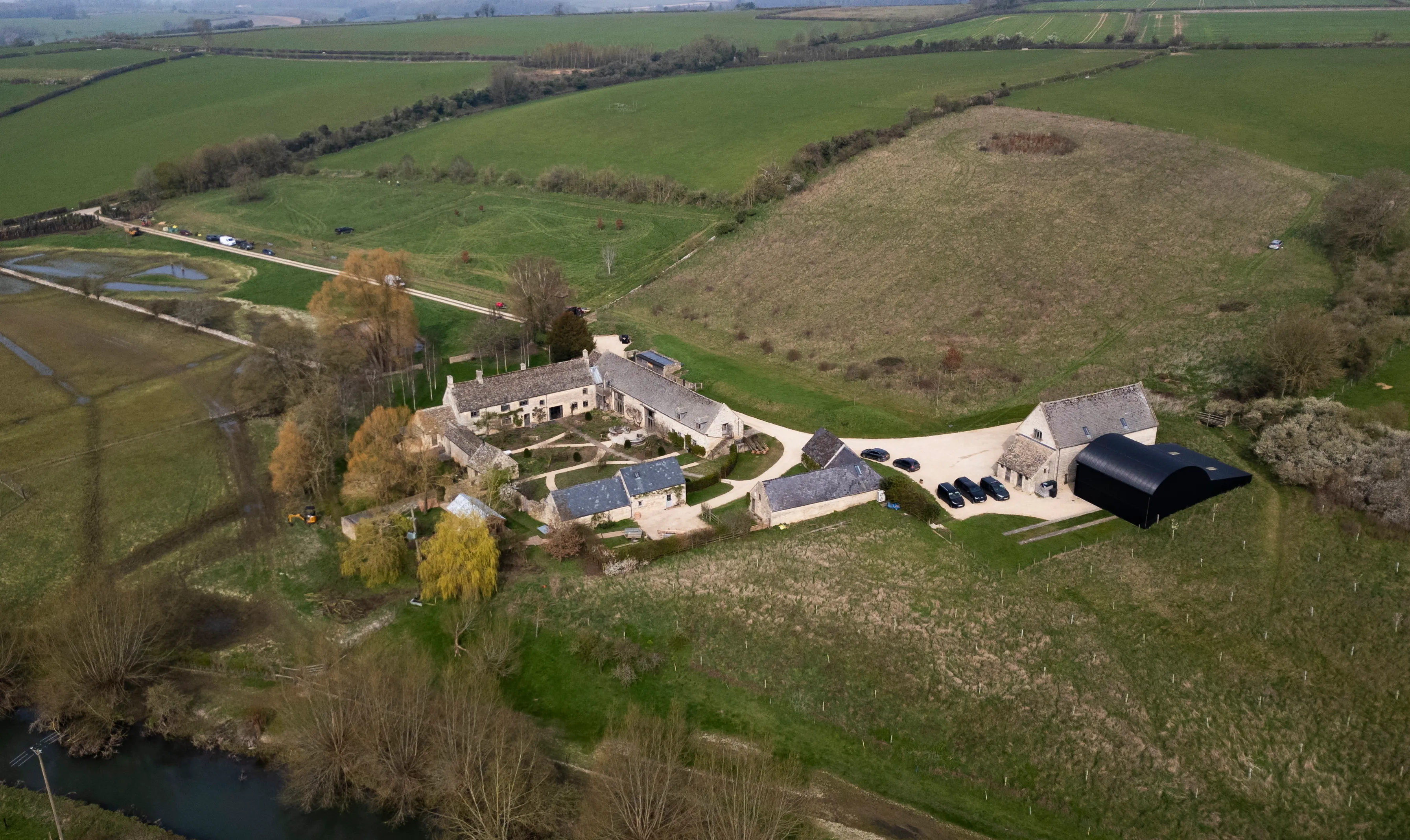 Aerial view of Ellen DeGeneres' Cotswolds home, with flooded fields surrounding the property.