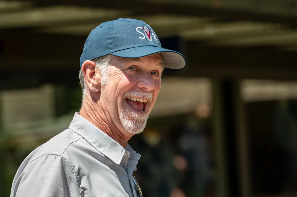 Reed Hastings, co-founder of Netflix Inc., smiling and wearing a blue cap.