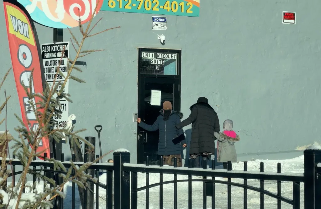 Adults and children arriving at the Quality Learning Center day care in Minneapolis.