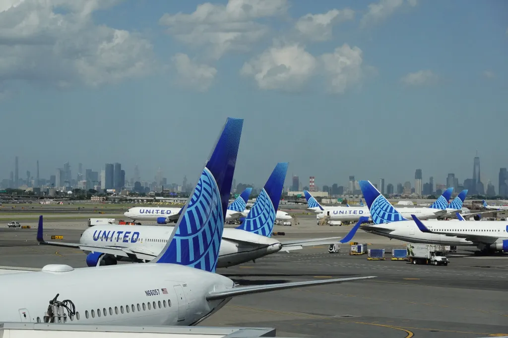 United Airlines planes on the tarmac at Newark Liberty International Airport's Terminal C, with the New York City skyline in the background.