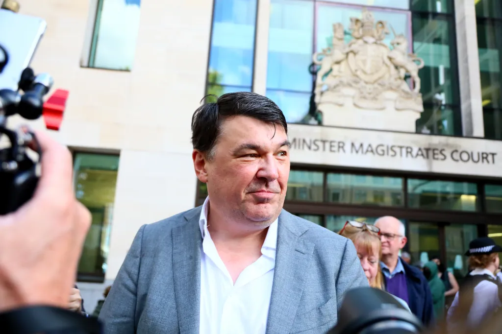 Graham Linehan outside Westminster Magistrates Court, surrounded by camera equipment and other people.