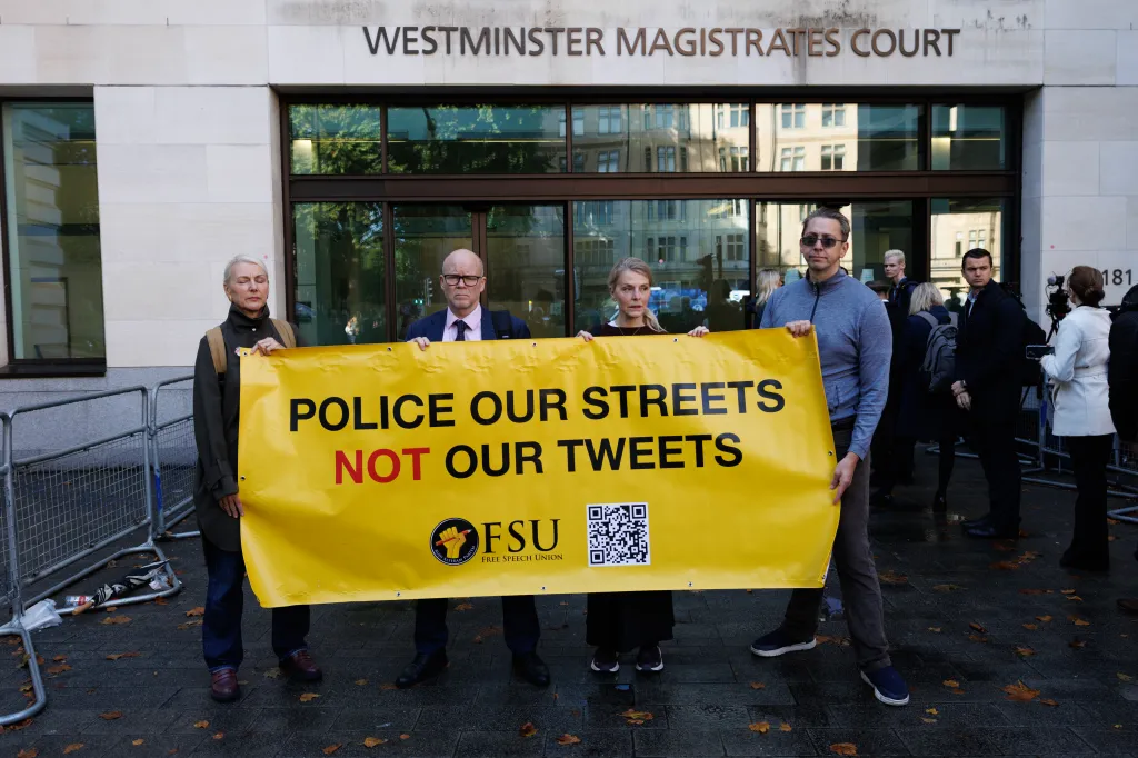 Protestors holding a banner outside Westminster Magistrates Court with 