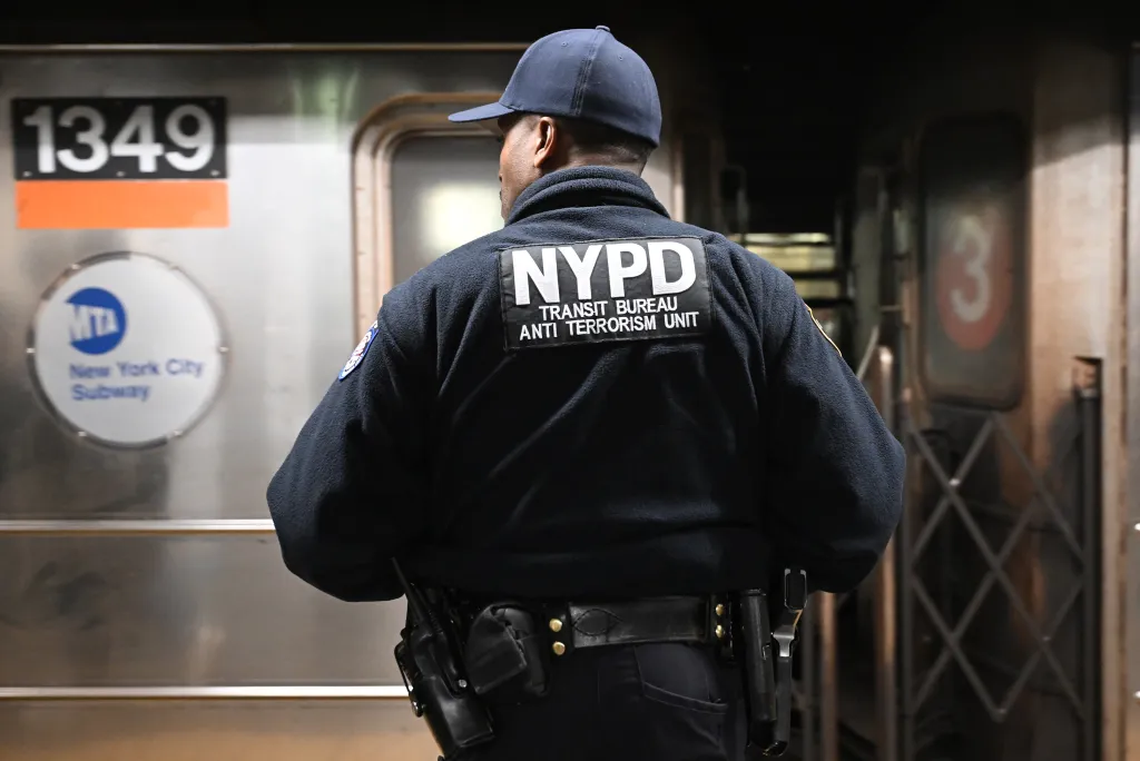 An NYPD officer from the Transit Bureau Anti Terrorism Unit stands in a subway station.