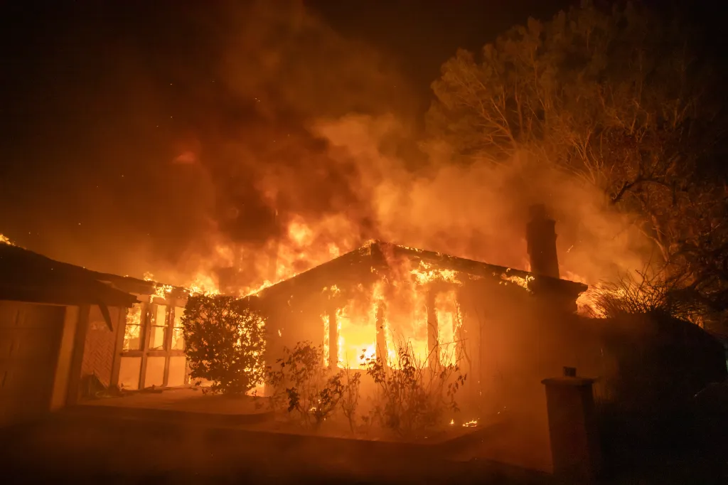 Palisades Fire engulfing a home in flames during a windstorm in Los Angeles.