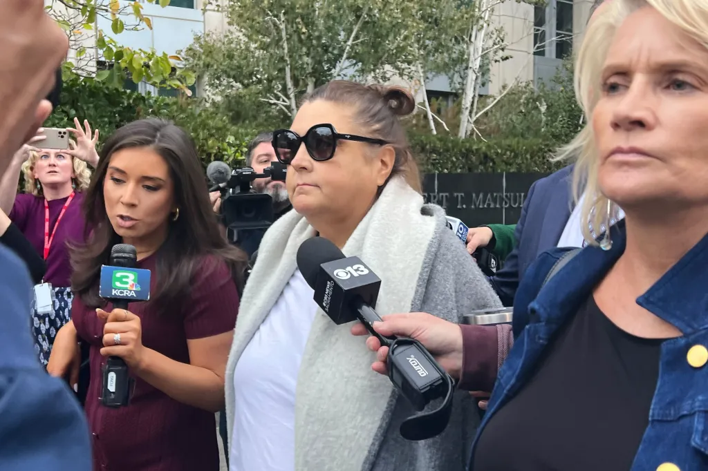 Dana Williamson, former aide to Gov. Gavin Newsom, surrounded by reporters after her indictment.