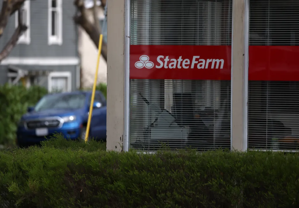 A red sign with the State Farm logo is displayed in the window of an office.