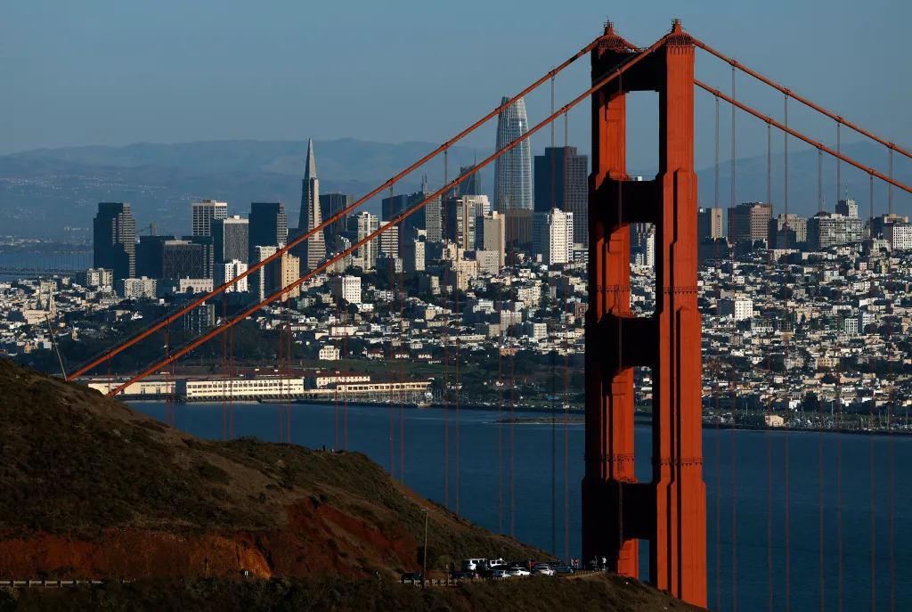 Aerial view of the Golden Gate Bridge in front of the San Francisco skyline.