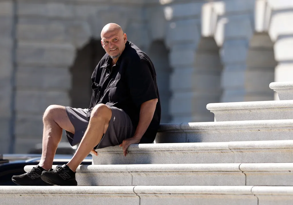 Sen. John Fetterman sits on the steps of the U.S. Capitol.