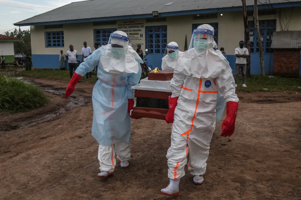 Medical staff in PPE carry a coffin from a hospital in the Democratic Republic of Congo.