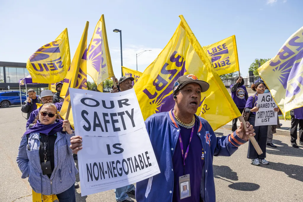A AGI worker holds a sign that says 