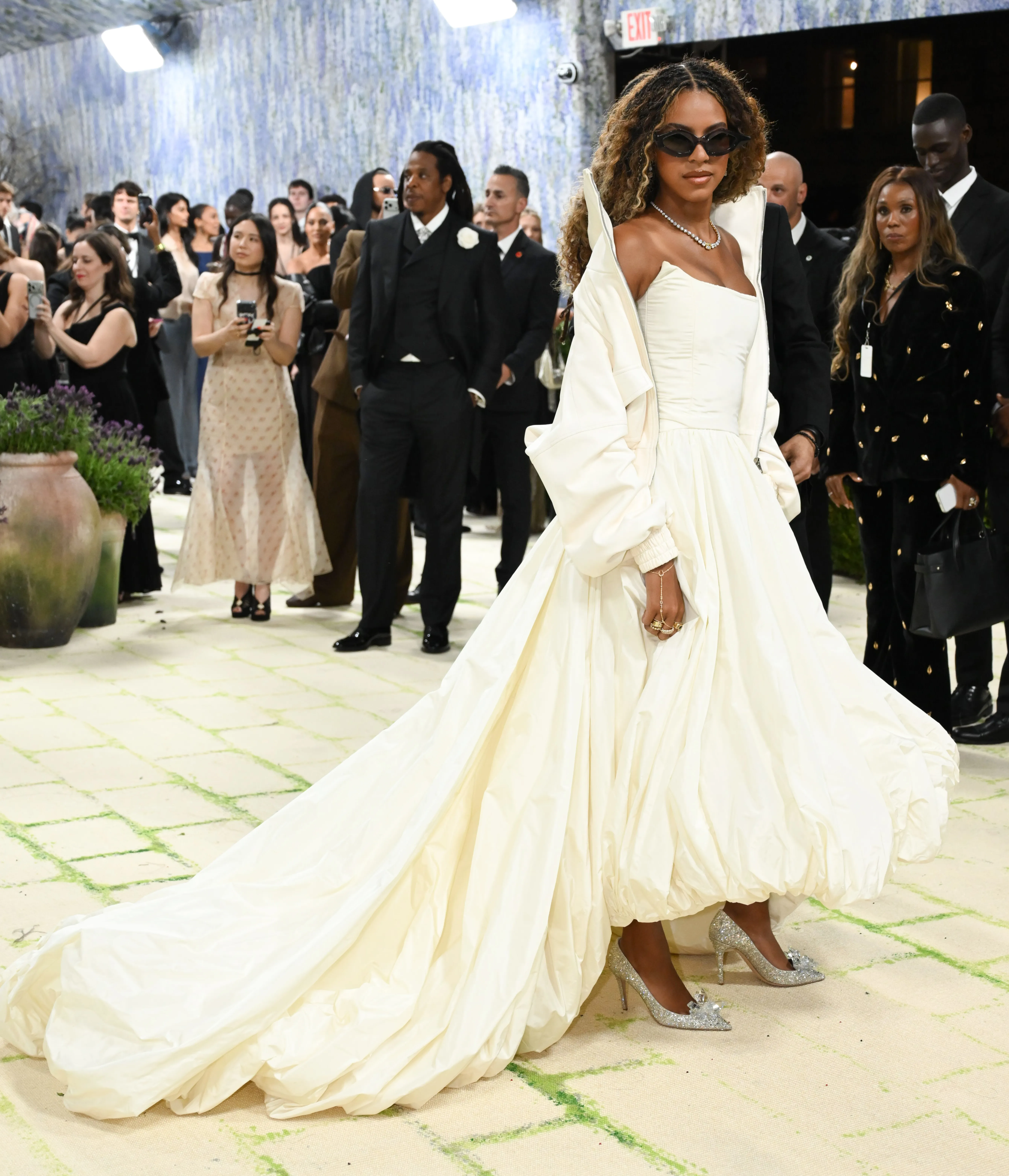 Blue Ivy Carter models a cream Balenciaga dress and bomber jacket with glittering silver heels at the Met Gala.