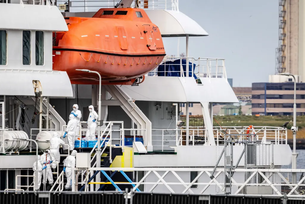 Personnel in personal protection equipment suits aboard the Dutch Hantavirus-hit cruise ship MV Hondius.