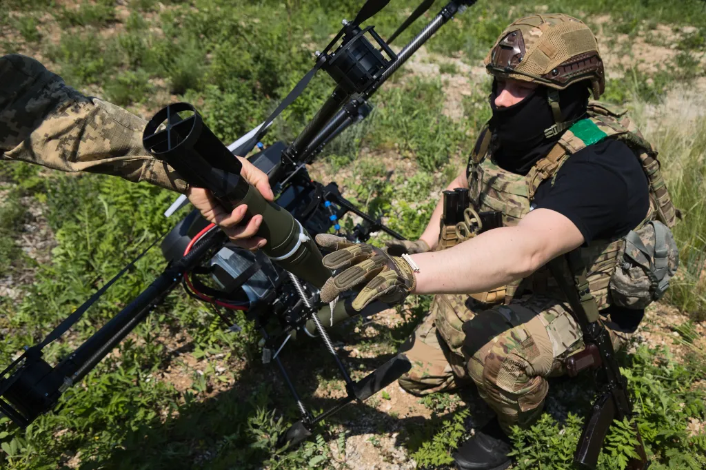 Two Ukrainian soldiers load munitions onto a Vampire heavy bomber drone.