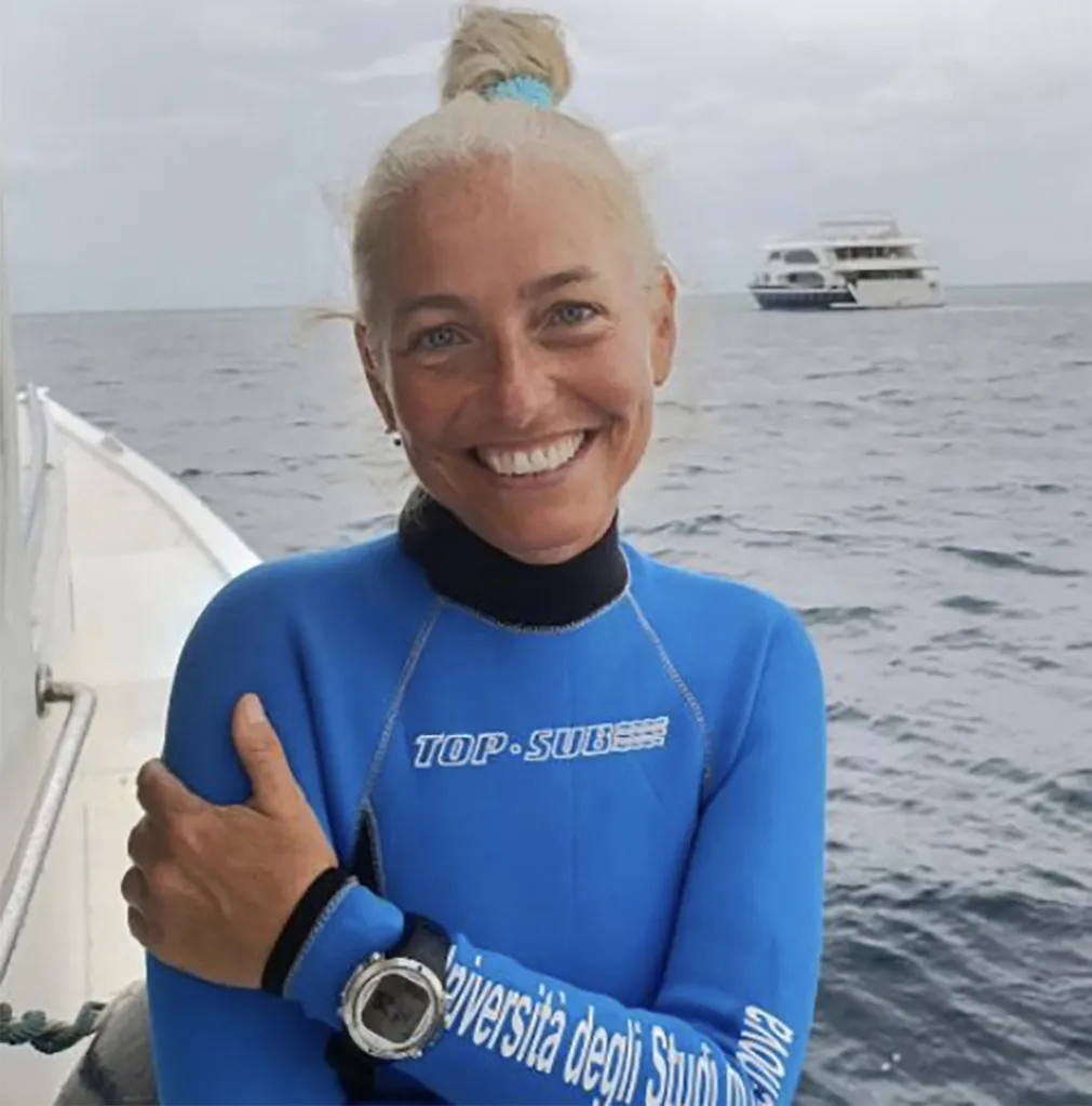 Monica Montefalcone, one of the Italian tourists who died during a dive in the Maldives, smiles while wearing a wetsuit on a boat.
