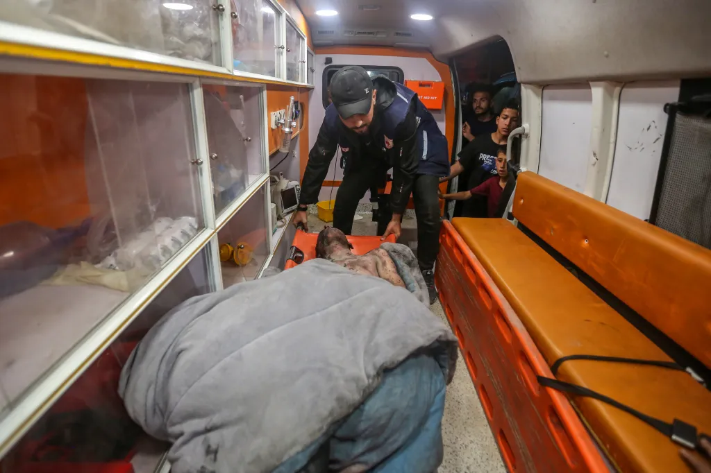 Emergency crews carry a young man who was injured following Israeli airstrikes on a residential building Gaza City on May 26, 2026.