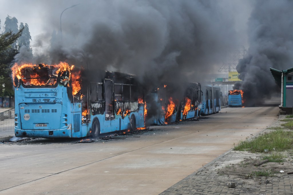 Public buses are set ablaze as clashes erupt in Dar es Salaam on October 29, 2025, during Tanzania's presidential elections.