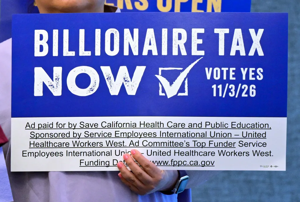A person holding a blue and white sign that reads 