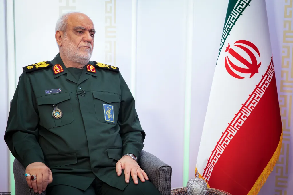 IRGC Intelligence Chief Majid Khademi in uniform, with an Iranian flag to his right.