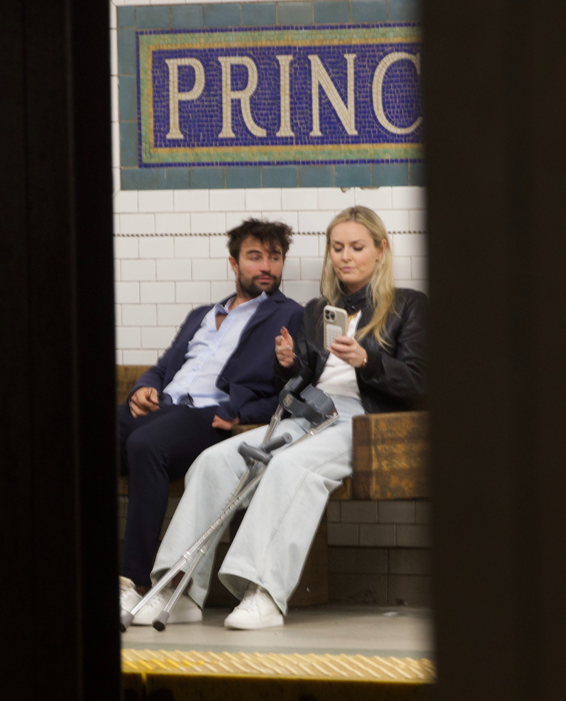Lindsey Vonn and Matthieu Bailet sitting on a subway platform.