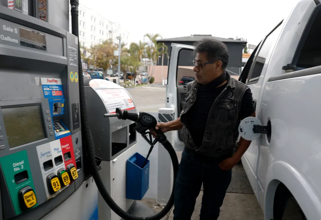 A customer pumps gas into his car at a Chevron station.