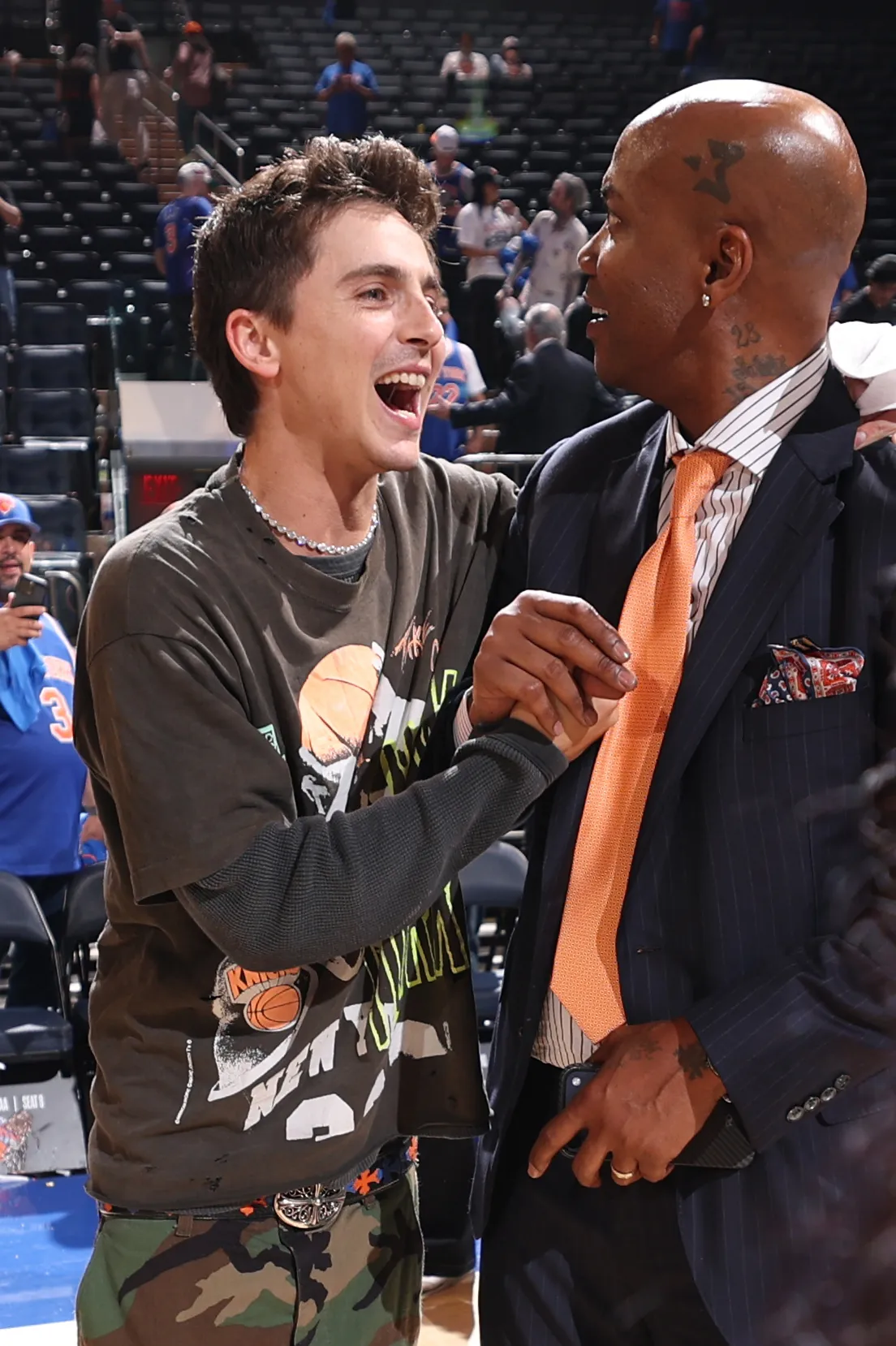 Timothée Chalamet and Stephon Marbury shake hands at a basketball game.