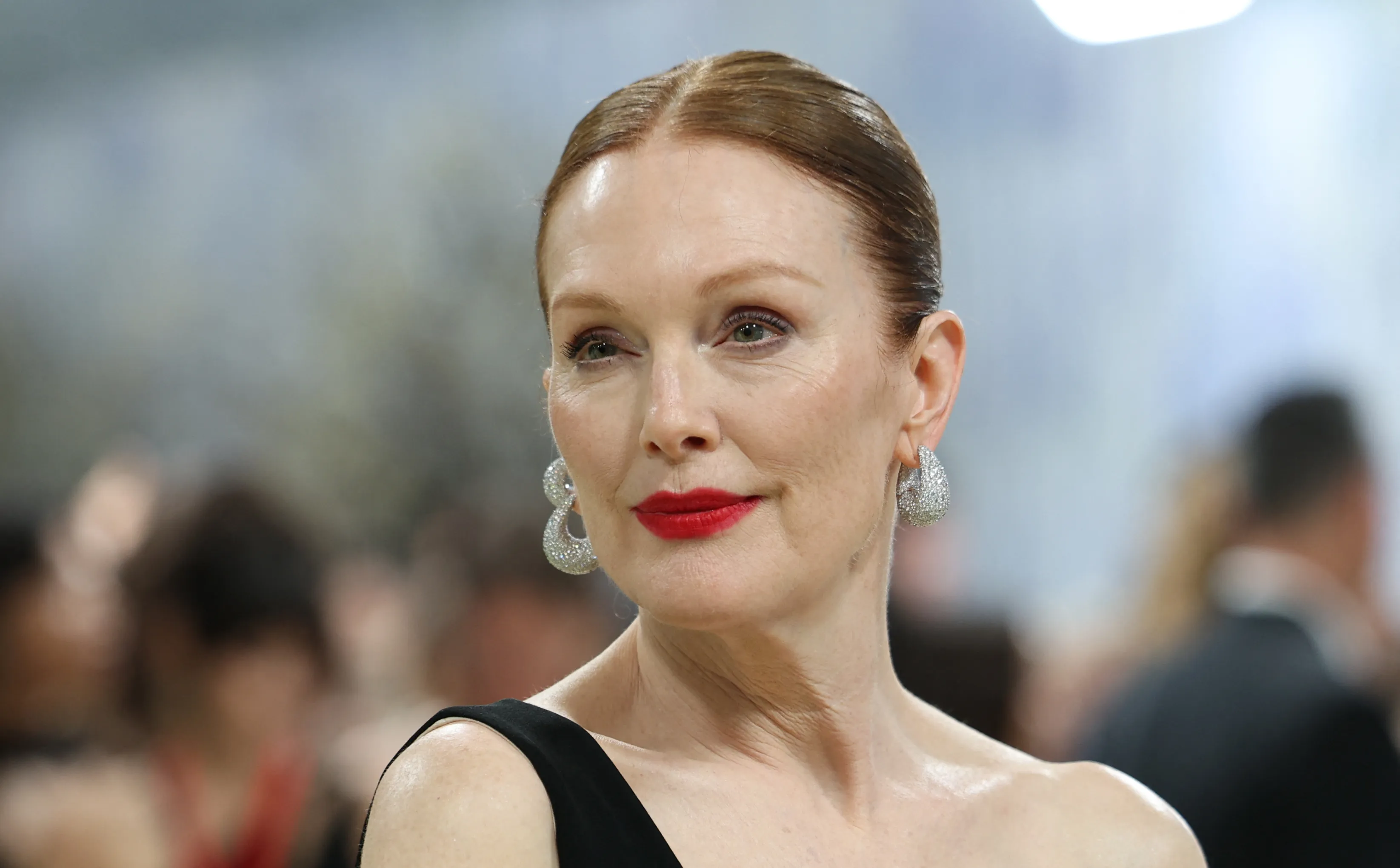 Julianne Moore wearing diamond earrings and red lipstick.