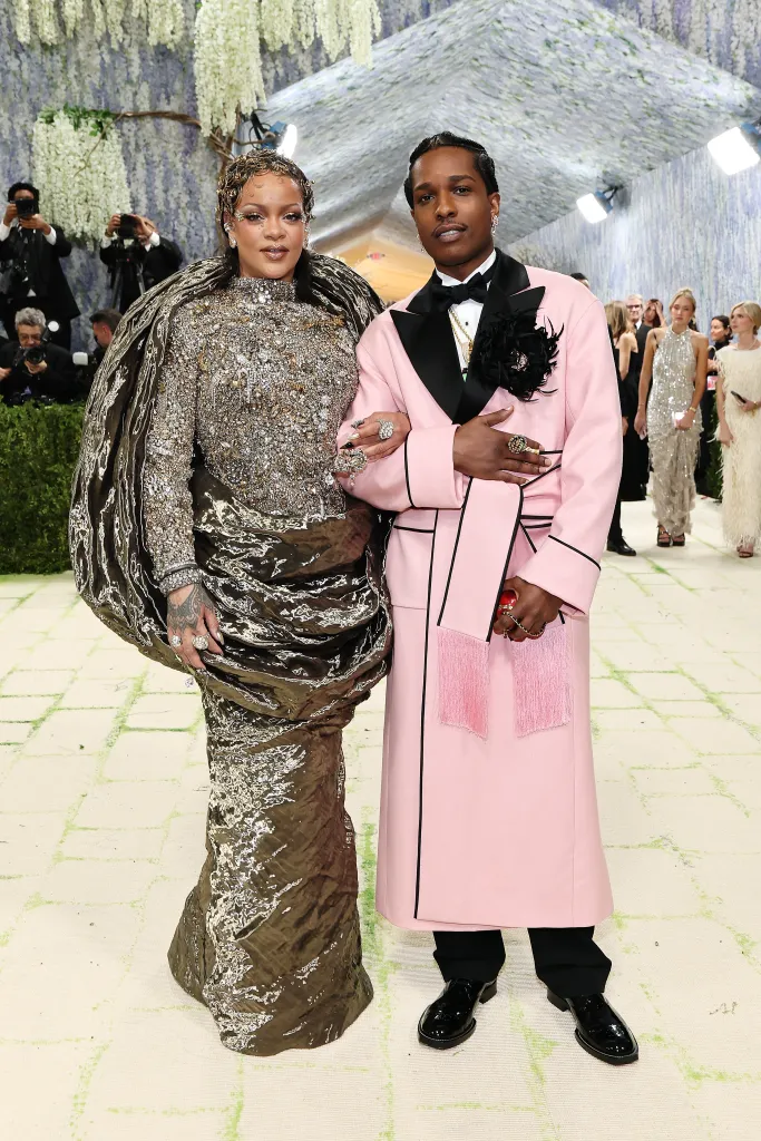 Rihanna, in a dark gown, and A$AP Rocky, in a pink coat, attend the 2026 Met Gala.