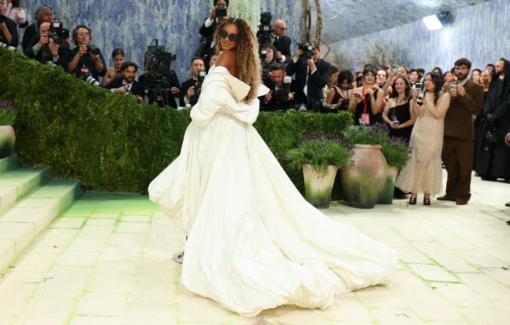 Blue Ivy Carter posing for cameras at the Met Gala in a large white gown.