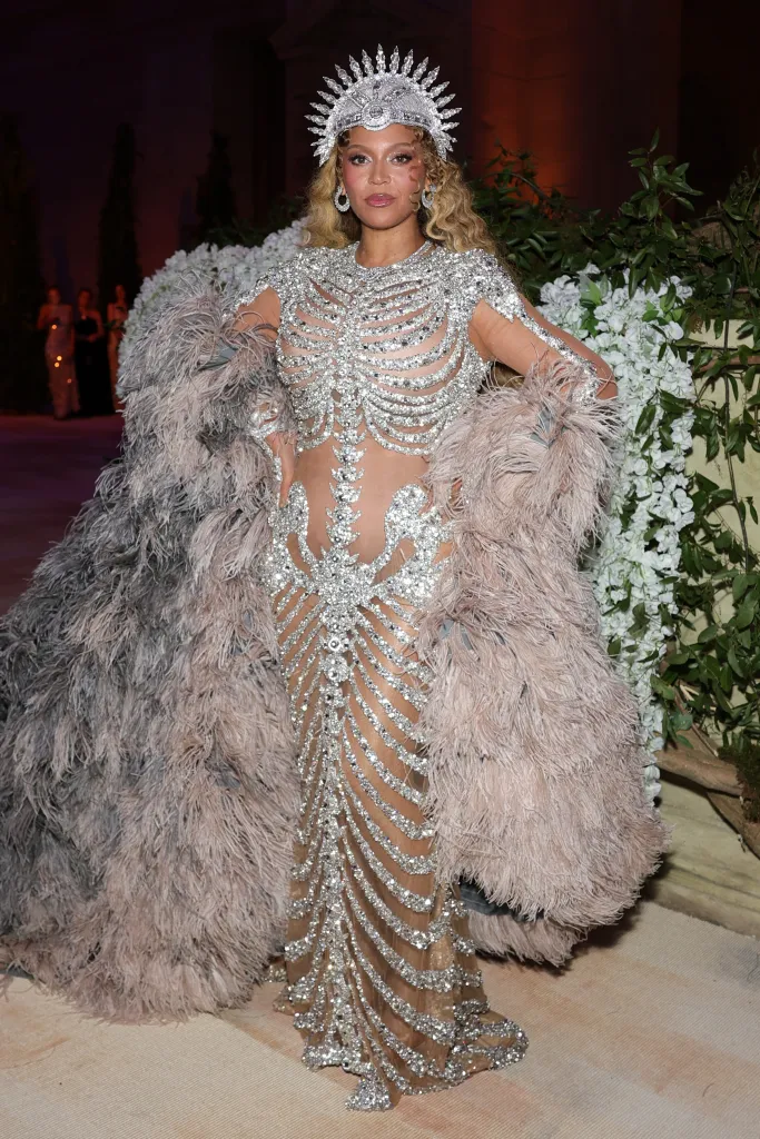 Beyoncé attends the 2026 Met Gala in a skeletal-motif, jewel-encrusted gown and large feathery boa.