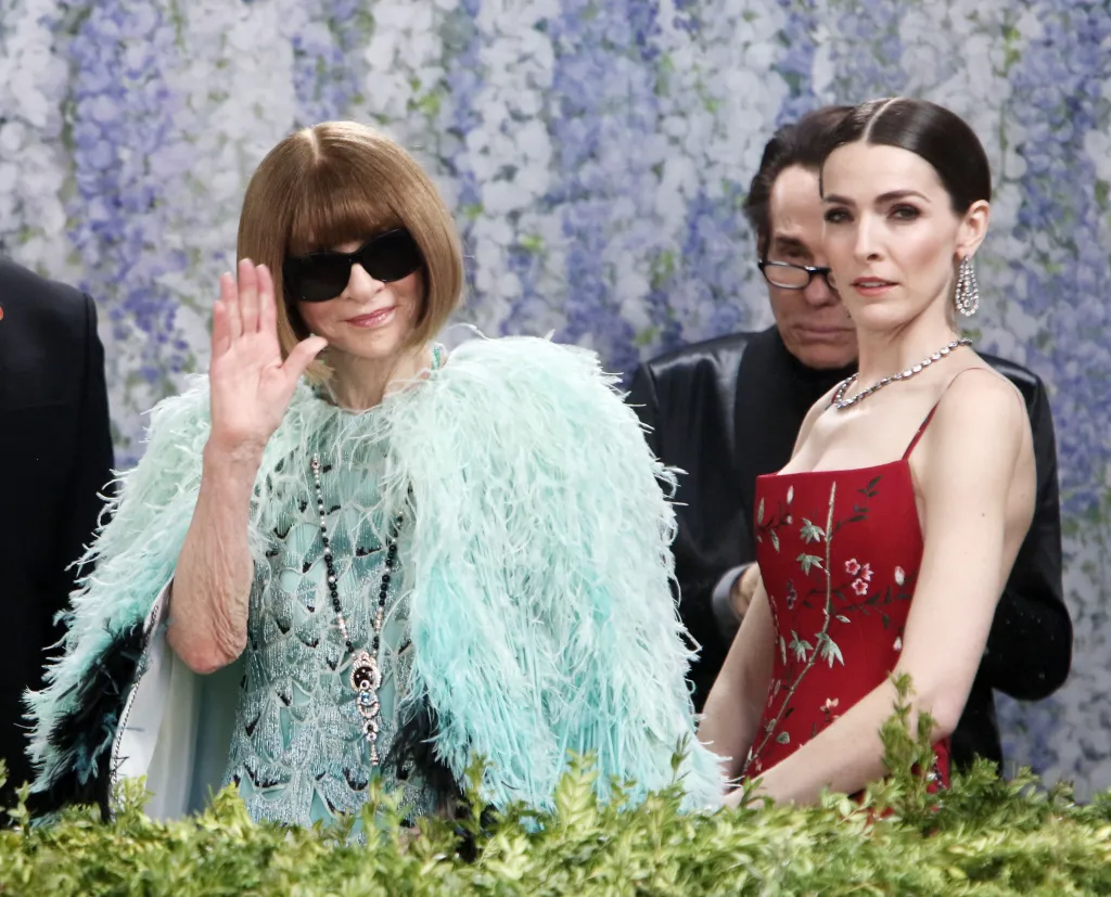 Anna Wintour, in sunglasses, green jacket and green and black gown, and Bee Carrozzini , in a red floral gown, at the 2026 Met Gala.