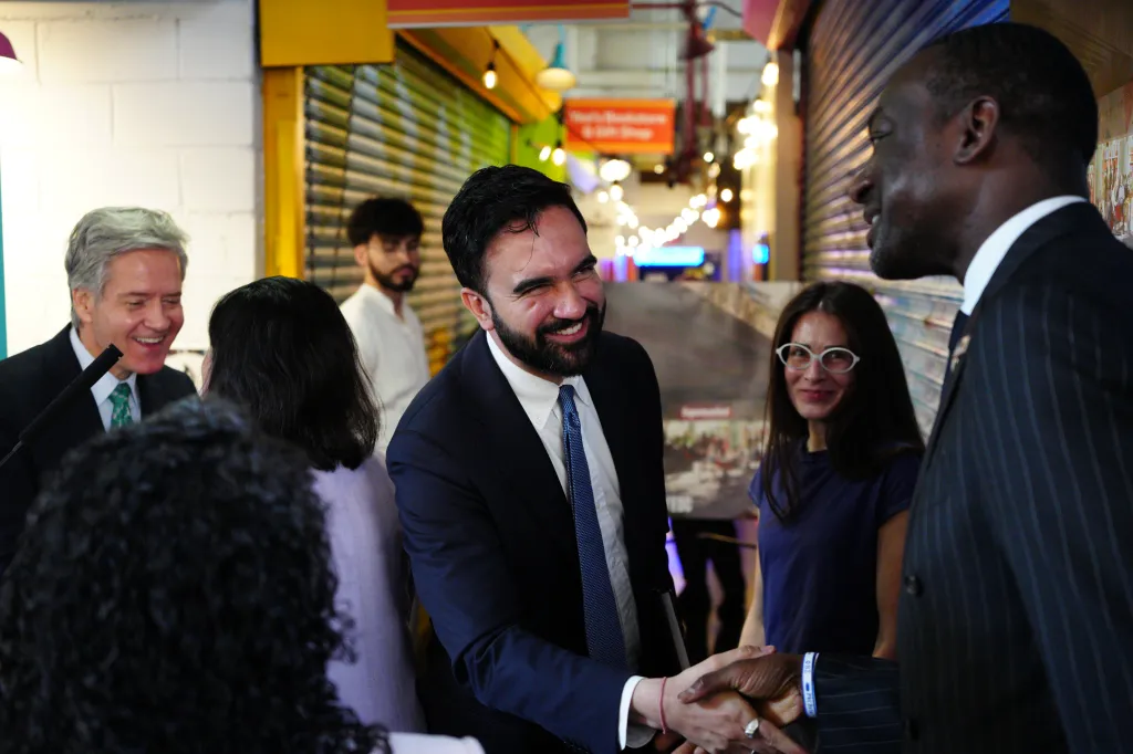 Mayor Zohran Mamdani shaking hands with another man.