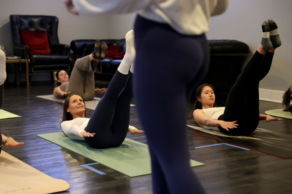 Women doing Pilates exercises on yoga mats.