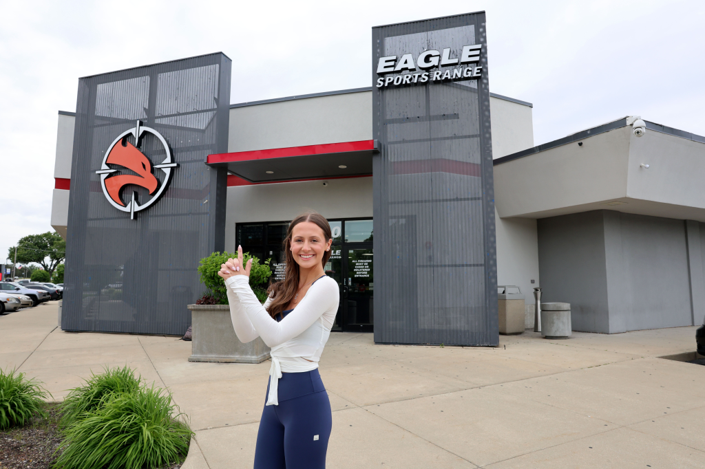 Georgia Worrell from the NY Posts posing with finger guns in front of Eagle Sports Range.